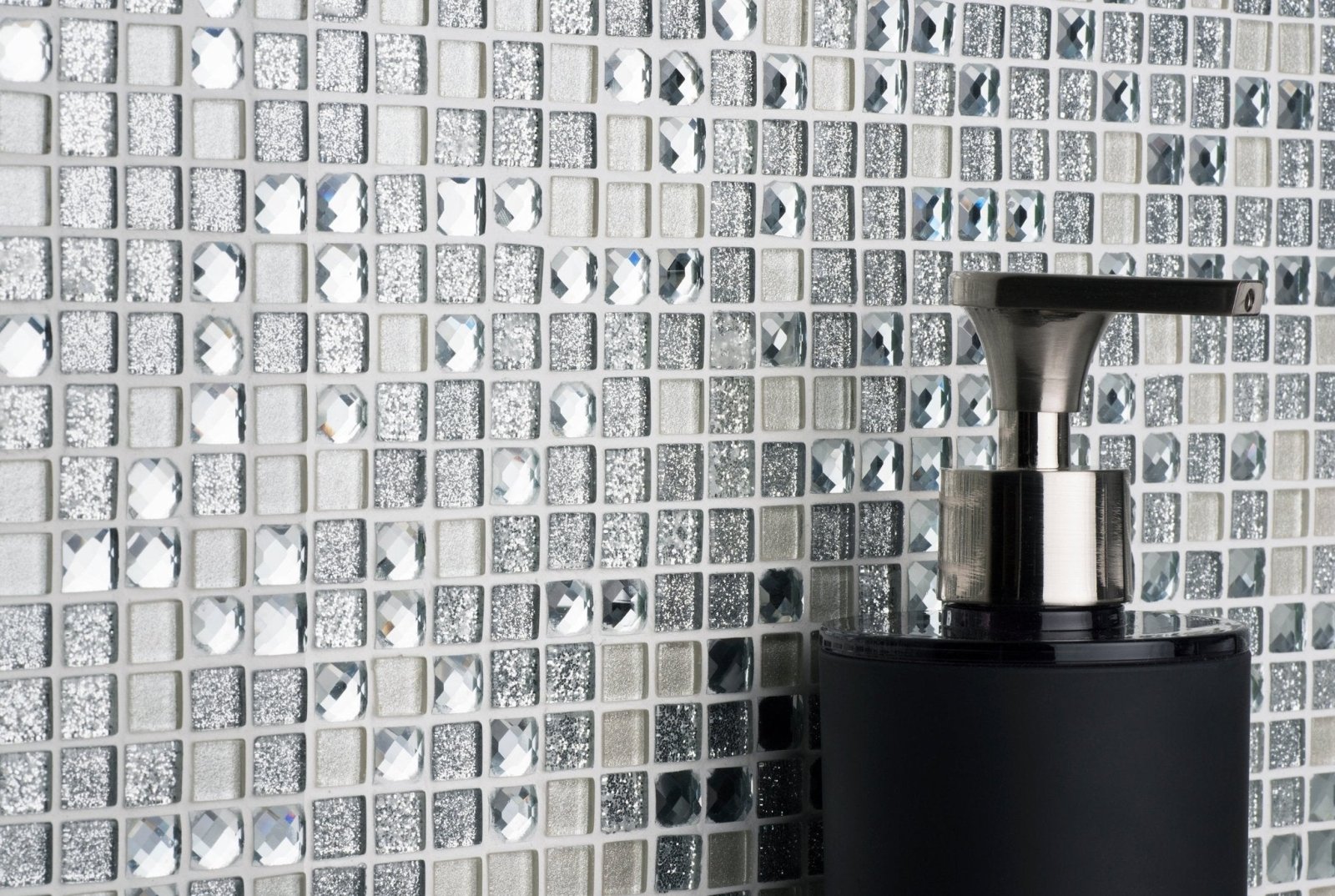 Black soap dispenser with a sleek metallic pump featured in a guide to the benefits of using glass mosaic tiles