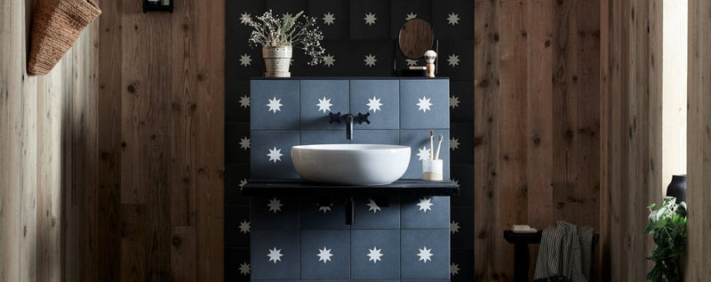 White ceramic vessel sink with modern design on dark gray tiled vanity with white star accents for easy cleaning tips