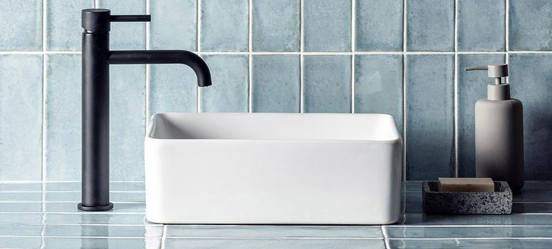 Black matte faucet with sleek modern design beside white rectangular ceramic sink for elevated interior design feature wall tiles