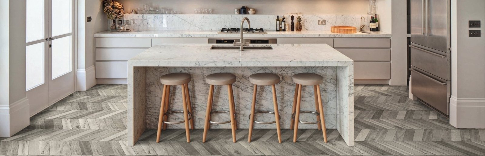 Modern kitchen island with white marble countertop and integrated sink with four wooden bar stools for tile inspiration