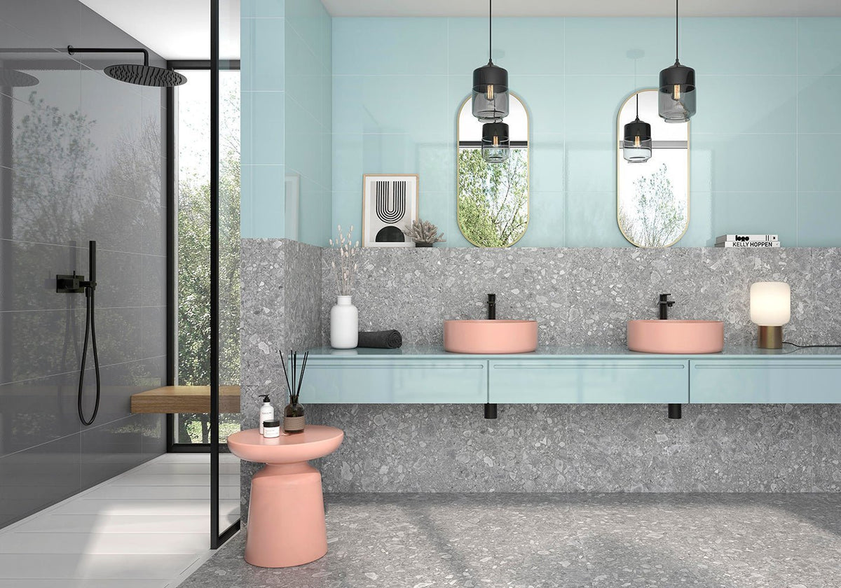 Pastel pink ceramic vessel sinks with smooth rounded edges on a light blue vanity in a porcelain tile flooring article