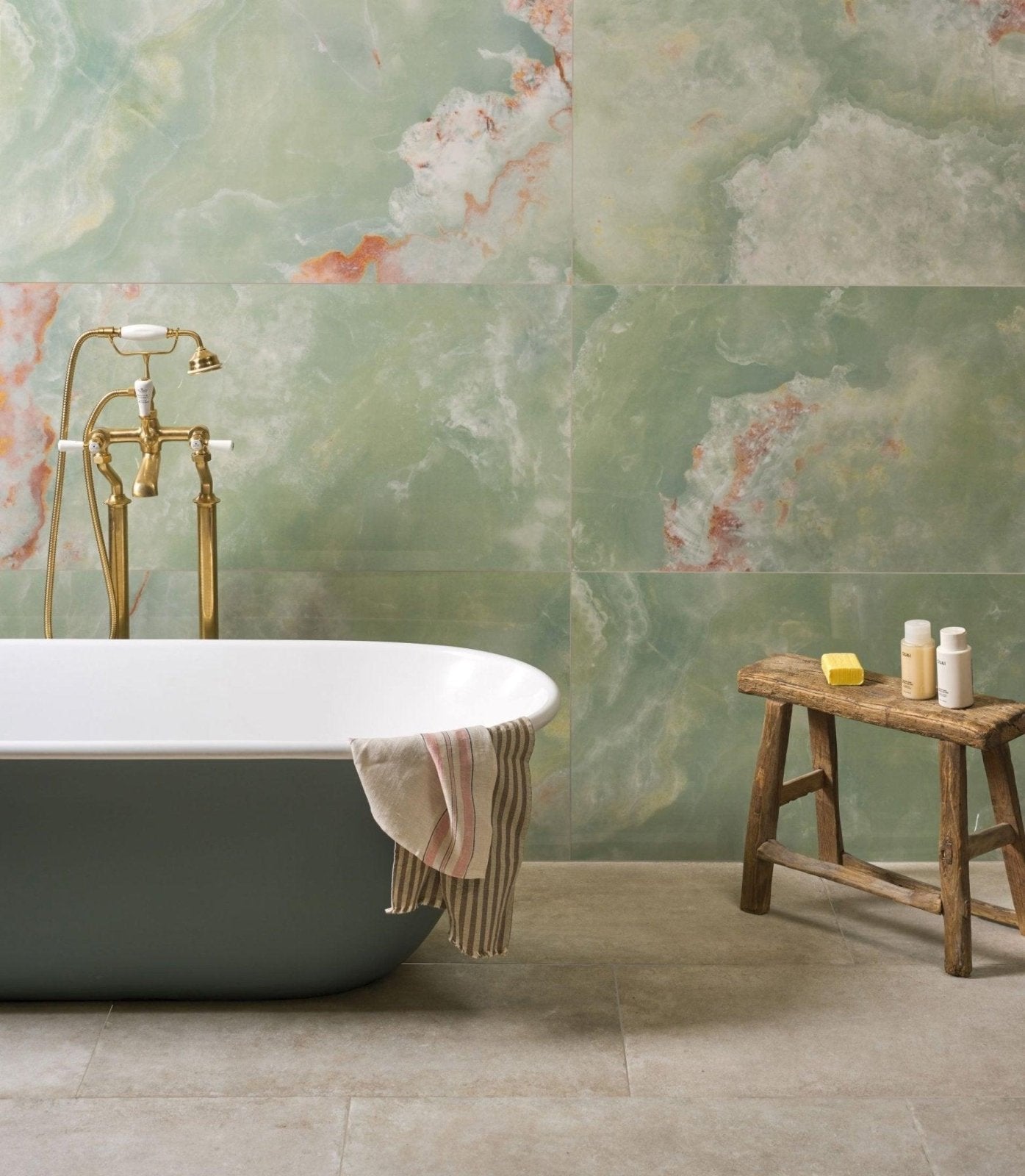 A freestanding matte gray porcelain bathtub with a white rim and towel showcasing porcelain tiles benefits in home design