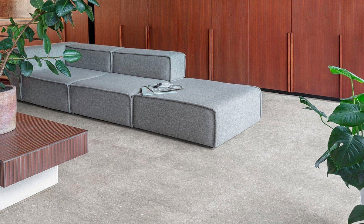 Modern gray modular sectional sofa with clean minimalist lines and soft fabric finish in durable living vinyl tile article context.