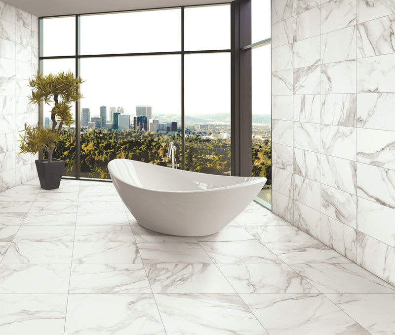 A sleek white freestanding bathtub with modern oval design in an elegant marble tiled bathroom with 30 x 60cm tiles