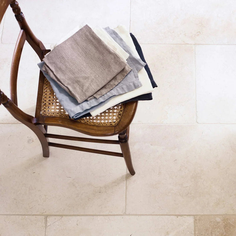 Stack of neatly folded linen napkins in beige gray and navy blue as part of 40 x 60cm floor tiles collection