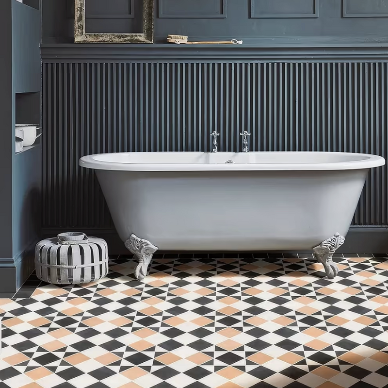A classic white freestanding bathtub with ornate silver claw feet in a victorian style tiles setting