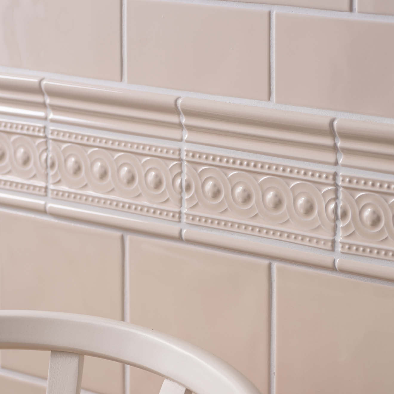 Beige ceramic tile border with raised oval and dot patterns from the artisan baroque moulding collection