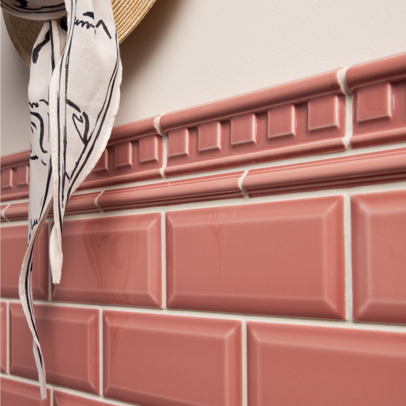 Pink glossy rectangular ceramic tiles with raised edges arranged in a brick pattern from artworks astragal moulding