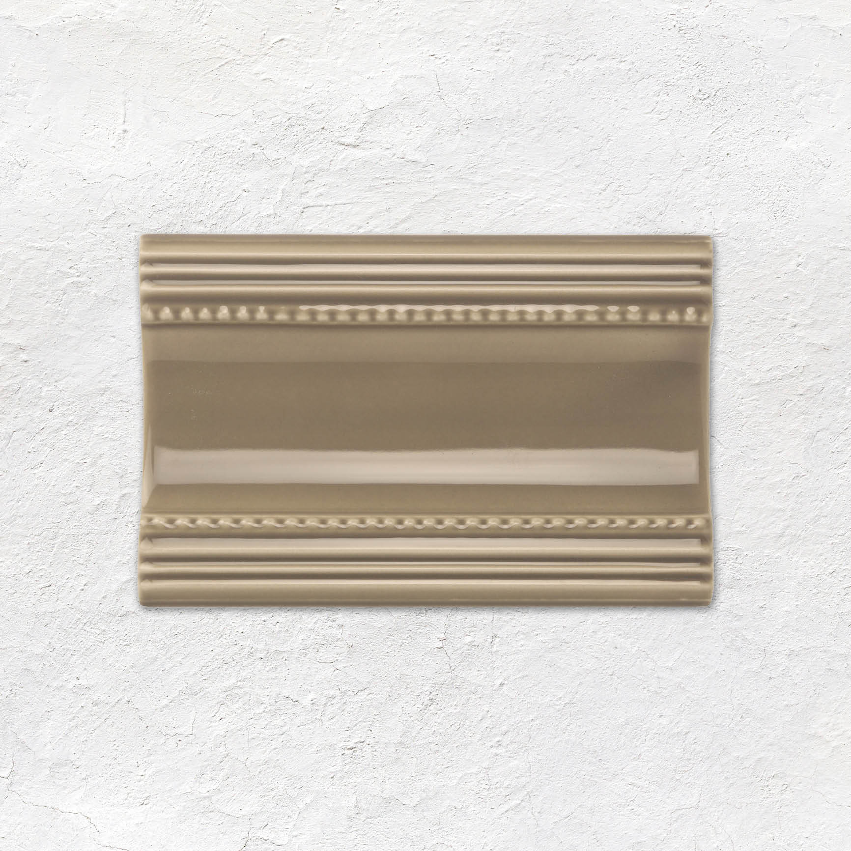 Beige ceramic wall tile from artworks cornice tile collection with decorative reeded and beaded border detailing