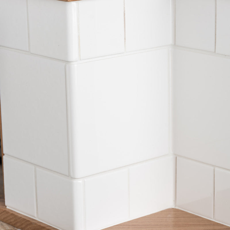 White square glossy tiles with smooth surfaces forming a clean corner wall for external wrapping use