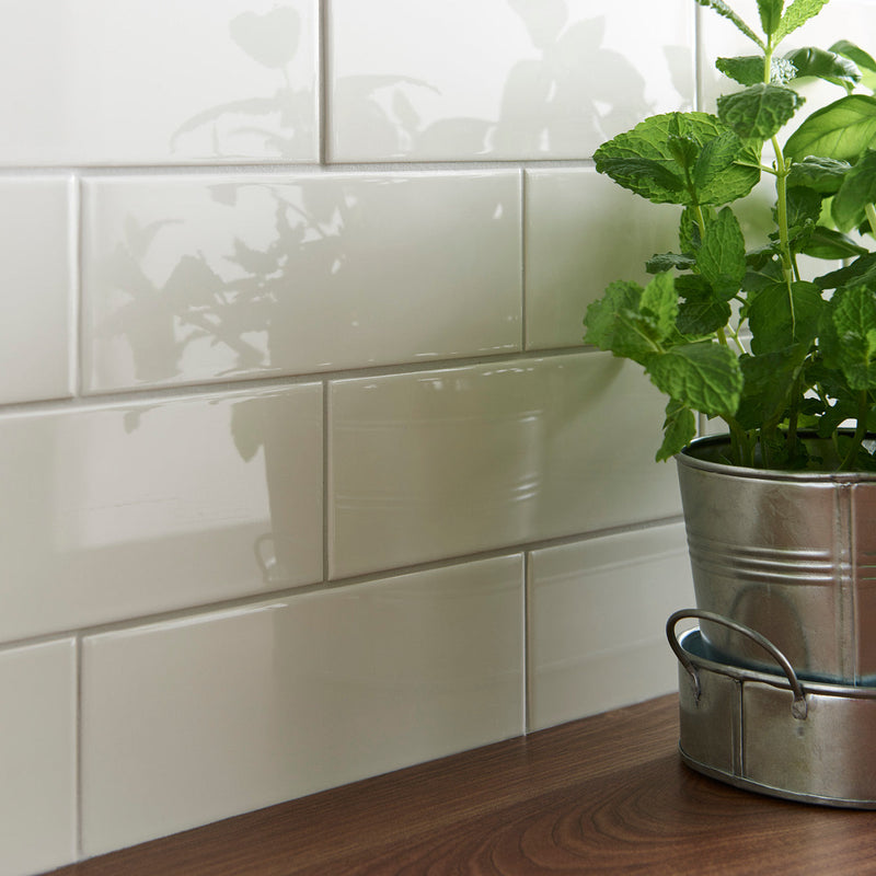 A metallic silver bucket with handle holding a vibrant green mint plant in artworks large brick tile collection