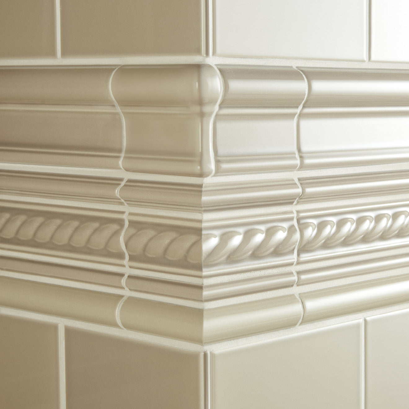 Cream-colored glossy ceramic tile molding with intricate rope and beaded patterns from artworks victoria moulding collection.