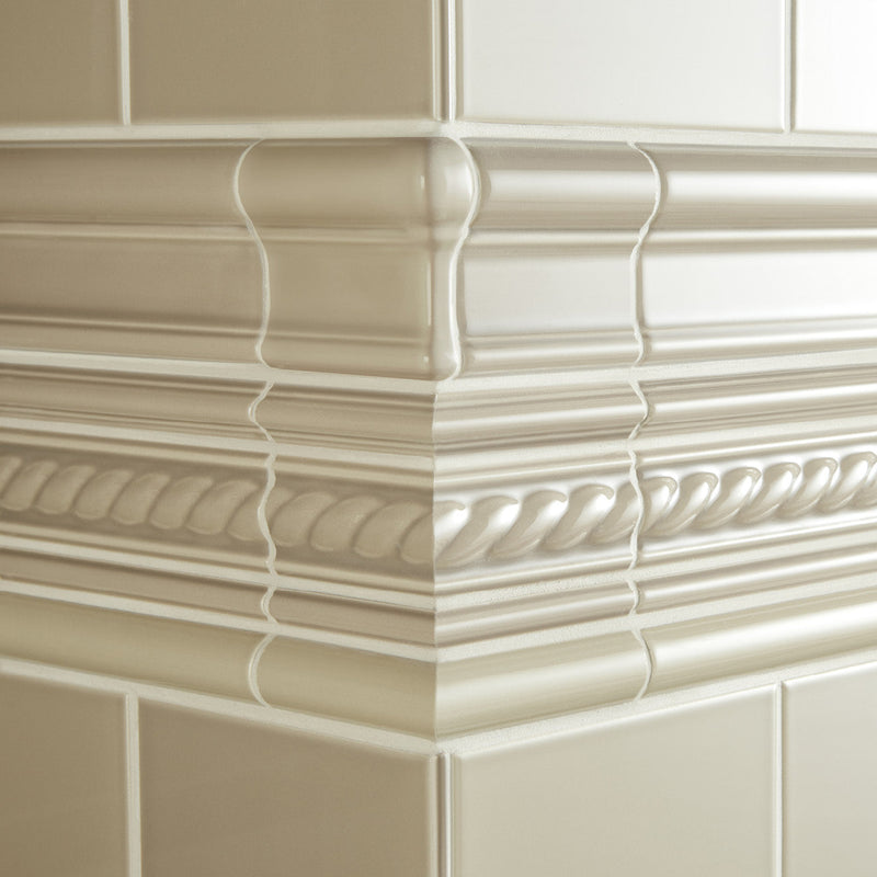 Cream-colored glossy ceramic tile molding with intricate rope and beaded patterns from artworks victoria moulding collection.