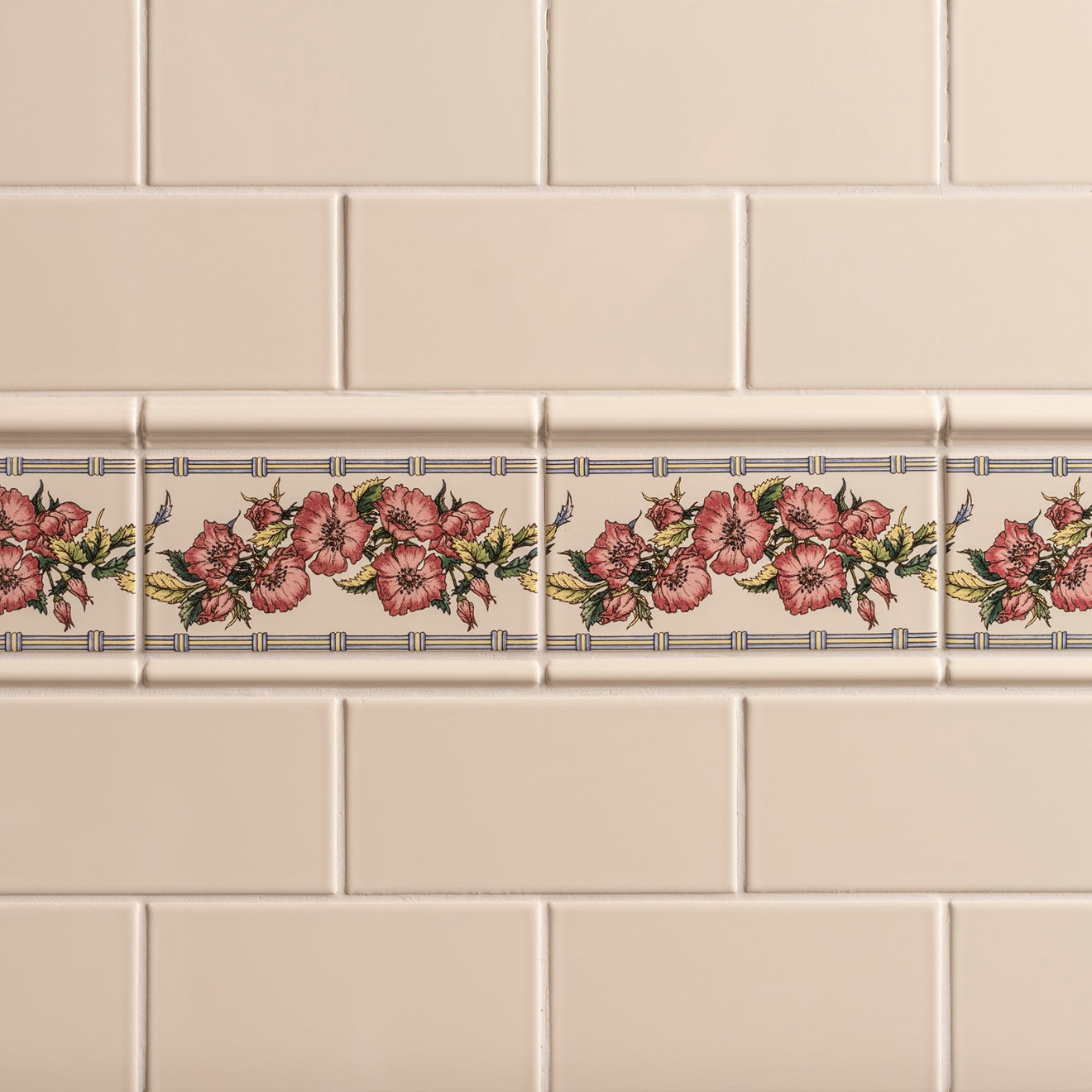 Beige ceramic tile border with repeating pink roses and green leaves framed by bamboo lines from corded poppies collection