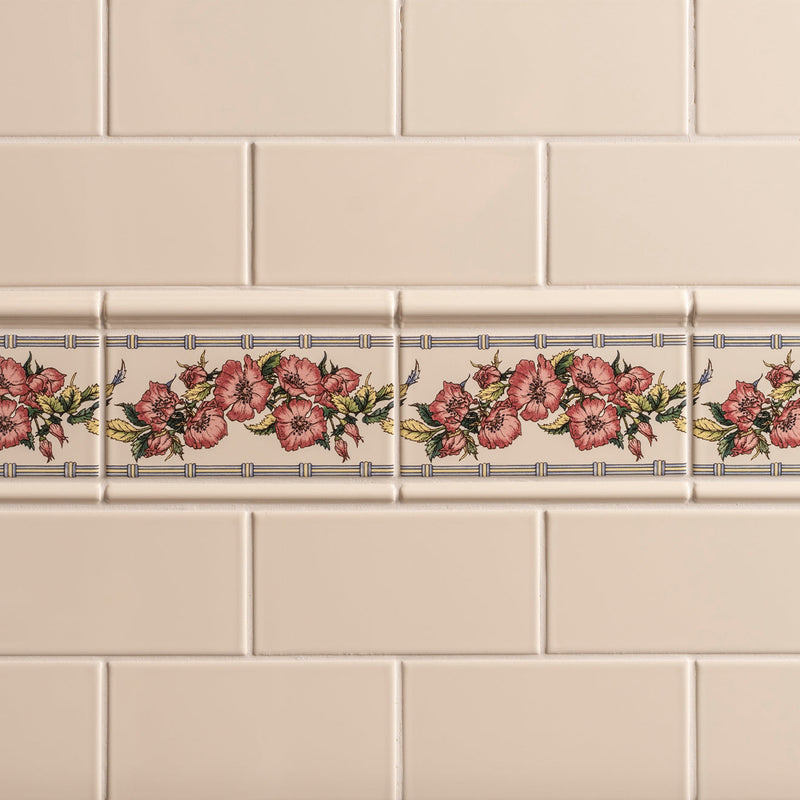 Beige ceramic tile border with repeating pink roses and green leaves framed by bamboo lines from corded poppies collection