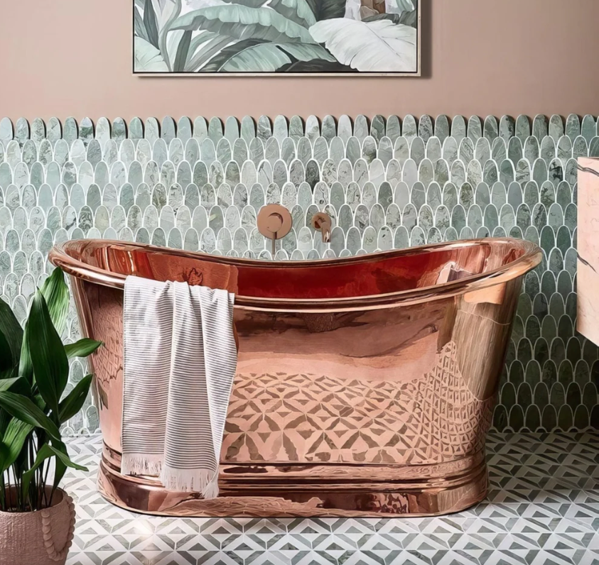 A polished copper bathtub with geometric etched patterns and rounded edges from the East Java Marble collection.