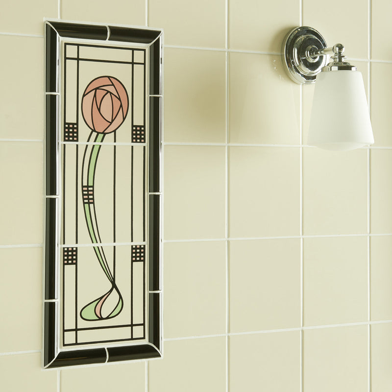 A rectangular stained glass panel featuring a pink rose with green stem in an art deco black frame from glasgow rose 3-tile panel