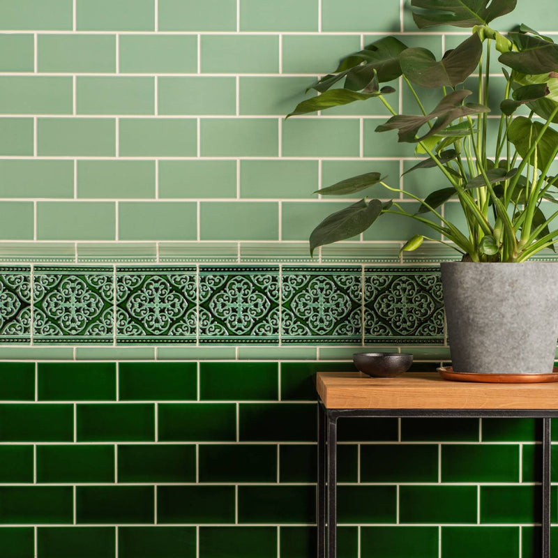 A textured gray ceramic planter from grosvenor jade breeze holding a lush green monstera plant on victorian green
