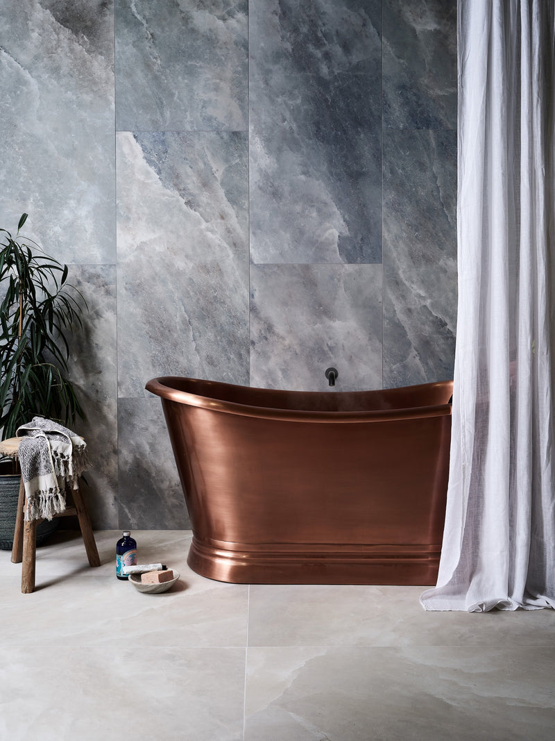 A sleek freestanding copper bathtub with polished finish and elegant curves from the Himalaya Porcelain collection