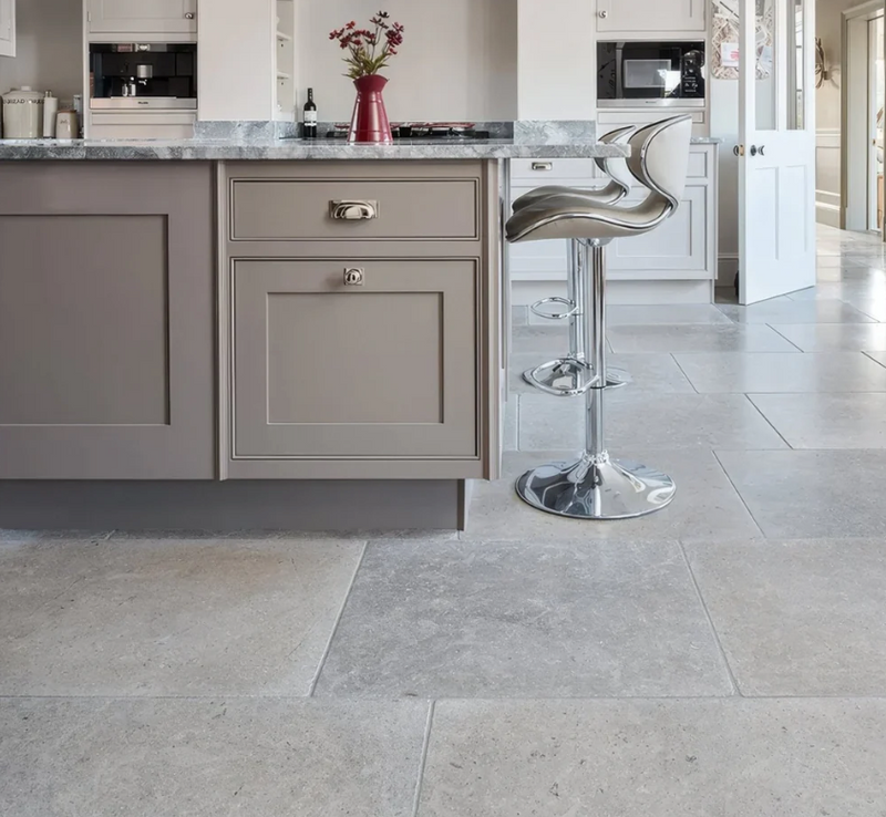 Modern chrome-finished bar stool with sleek curved seat and pedestal base in kimmeridge limestone collection