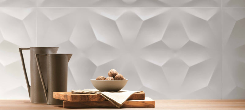 A minimalist ceramic bowl with a smooth matte finish holding round textured nuts in a 3d look wall design collection