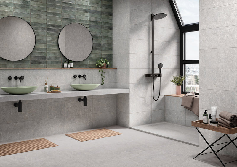 Modern bathroom featuring two light green ceramic vessel sinks with black matte faucets on a concrete countertop