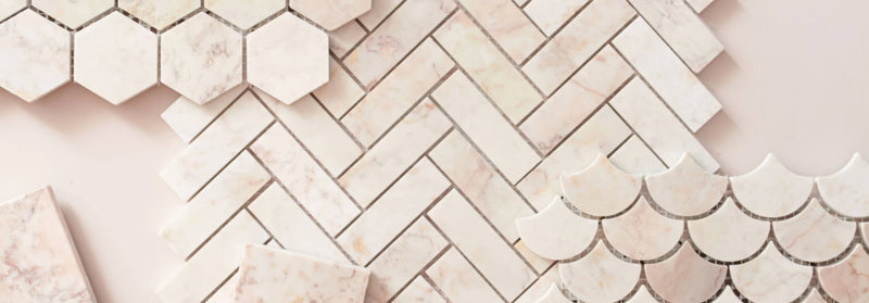 White marble hexagonal rectangular and scalloped tiles in a herringbone pattern from the aegean pink marble collection
