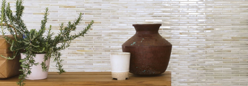 A rustic brown ceramic vase with a wide rounded body and flared rim on a wooden surface in Arabian Sea Glass Mosaics.