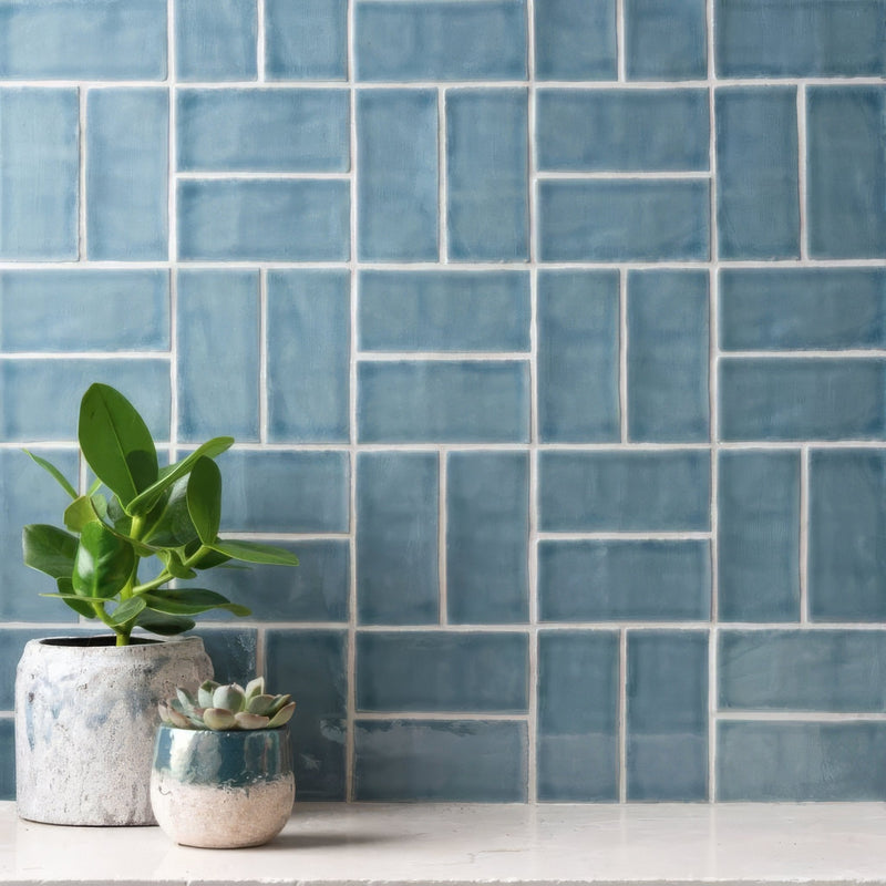 Blue rectangular ceramic tiles with white grout forming a modern textured backsplash from the arcadian half tile collection