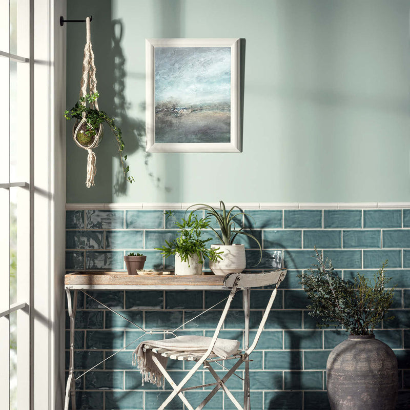 White framed abstract painting with soft blue and gray brushstrokes hanging on a mint green wall from arcadian ogee moulding collection