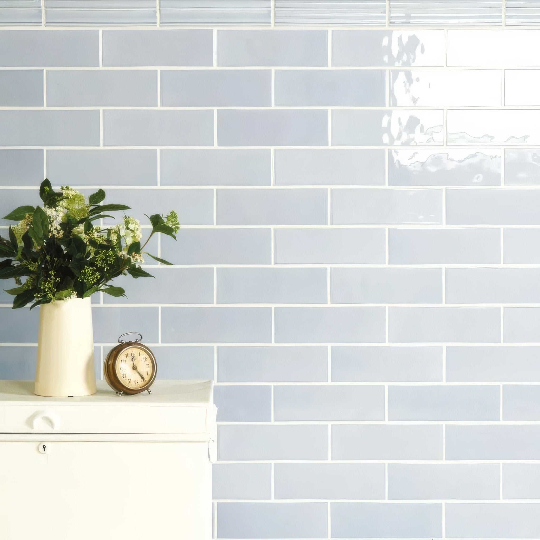 Light blue rectangular subway tiles in artisan 225mm brick style with white grout create a sleek modern wall design
