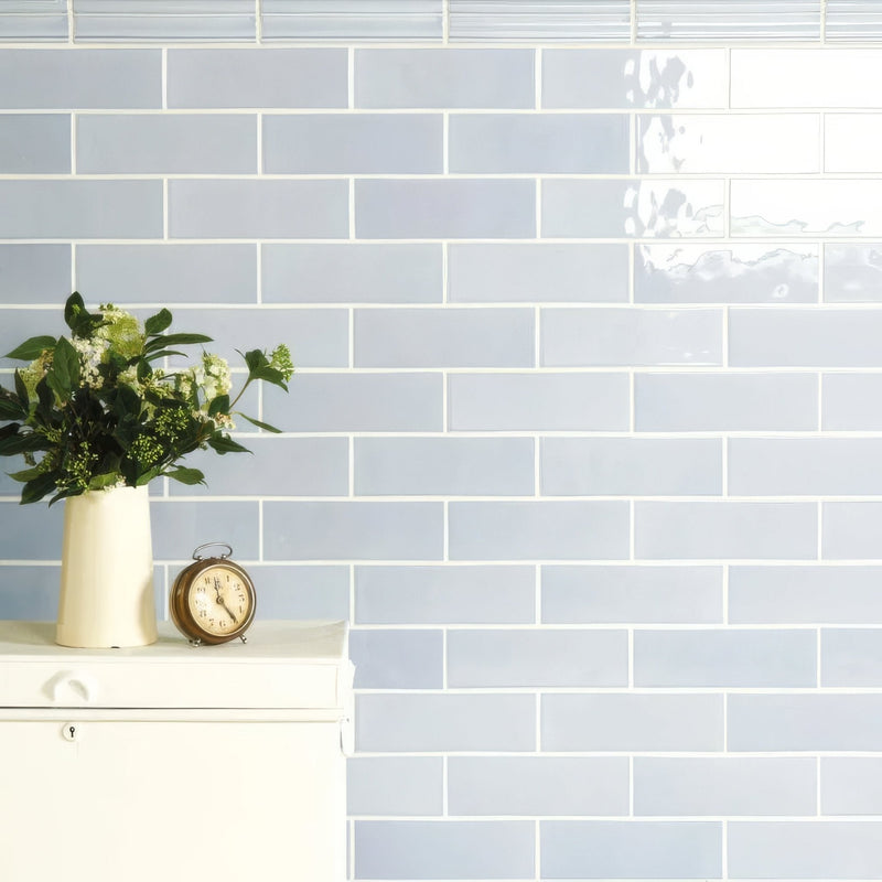 Light blue rectangular subway tiles in artisan 225mm brick style with white grout create a sleek modern wall design