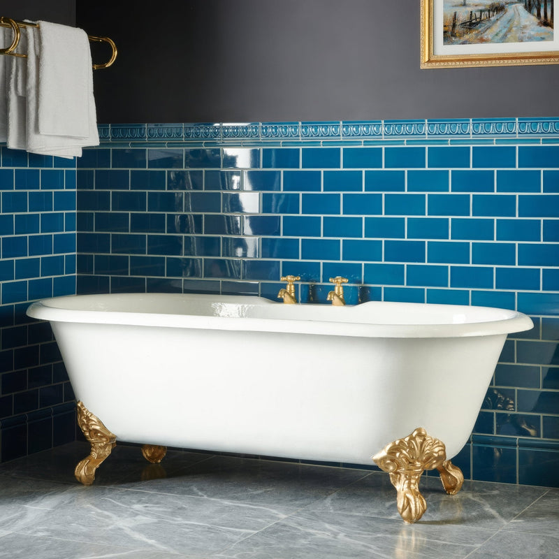 White clawfoot bathtub with gold-finished ornate feet and fixtures from the Artworks Baroque Blue Collection