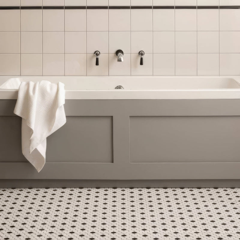 Gray panelled bathtub from artworks chancel grey collection with white tiled wall and black fixtures