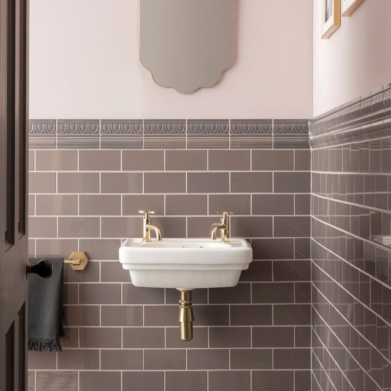 White ceramic wall-mounted sink with gold-toned faucets and plumbing from artworks london stone collection
