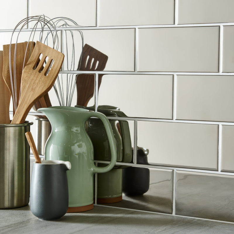 A matte sage green ceramic pitcher with a curved handle and terracotta base from artworks platinum collection