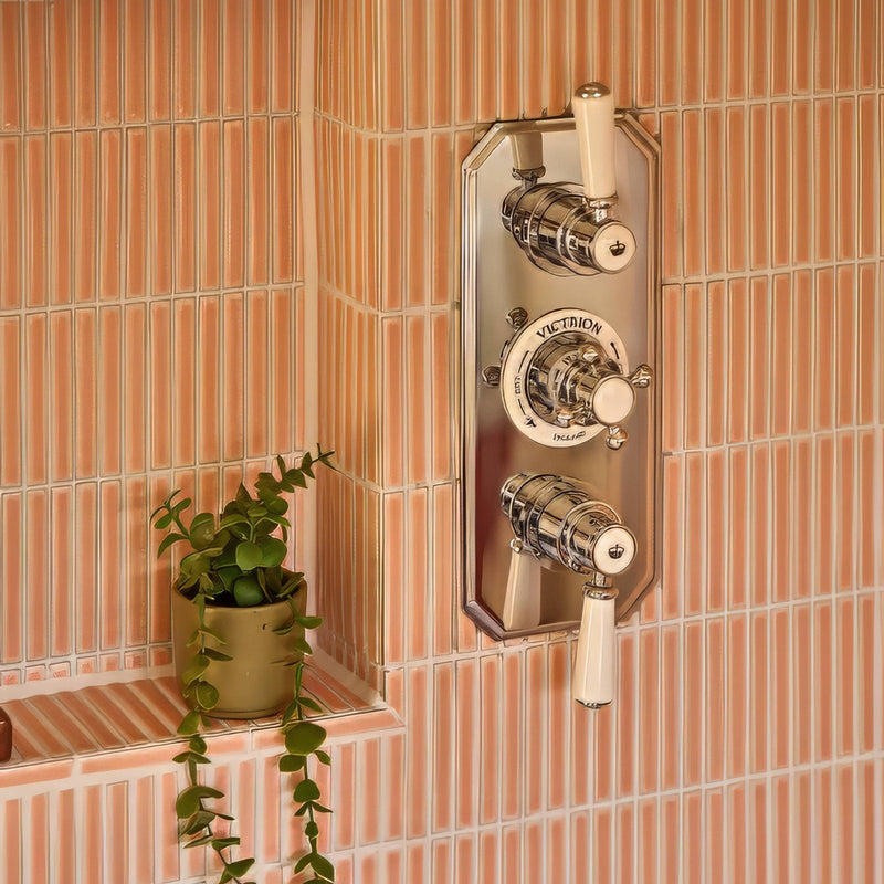Chrome-finished victorians shower mixer with cream ceramic handles against pink striped tiles in bamboo porcelain mosaics collection