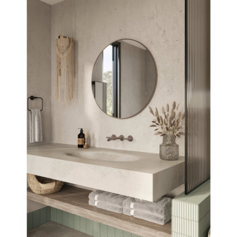 Round mirror with sleek minimalist black metal frame mounted above bathroom sink in bathroom accessories storage and mirrors collection