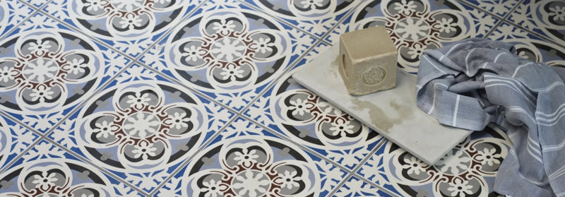 Beige rectangular bar of soap with embossed floral design resting on a light gray stone slab in bathroom floor tiles collection