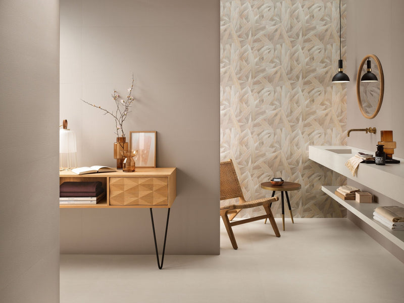 The wooden console table with a geometrically patterned front panel and slender black metal legs for beige bathroom tiles