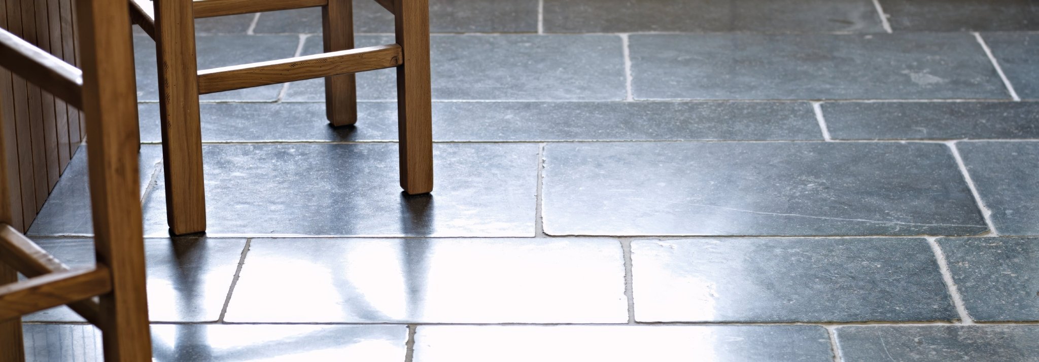 Dark gray slate tiles with subtle natural veining and polished reflective surface from belgian bleu stone collection