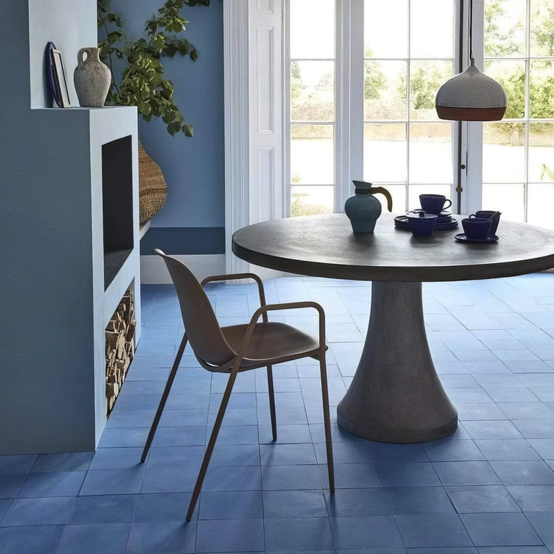 Round concrete table with wide flared base and smooth matte surface from bert and may porcelain plain tiles collection