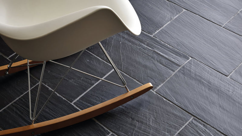 A sleek white rocking chair with chrome legs and wooden rockers featured in a black kitchen tiles collection