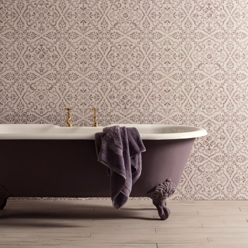 Purple clawfoot bathtub with white porcelain interior and gold toned faucets from the bohemia collection