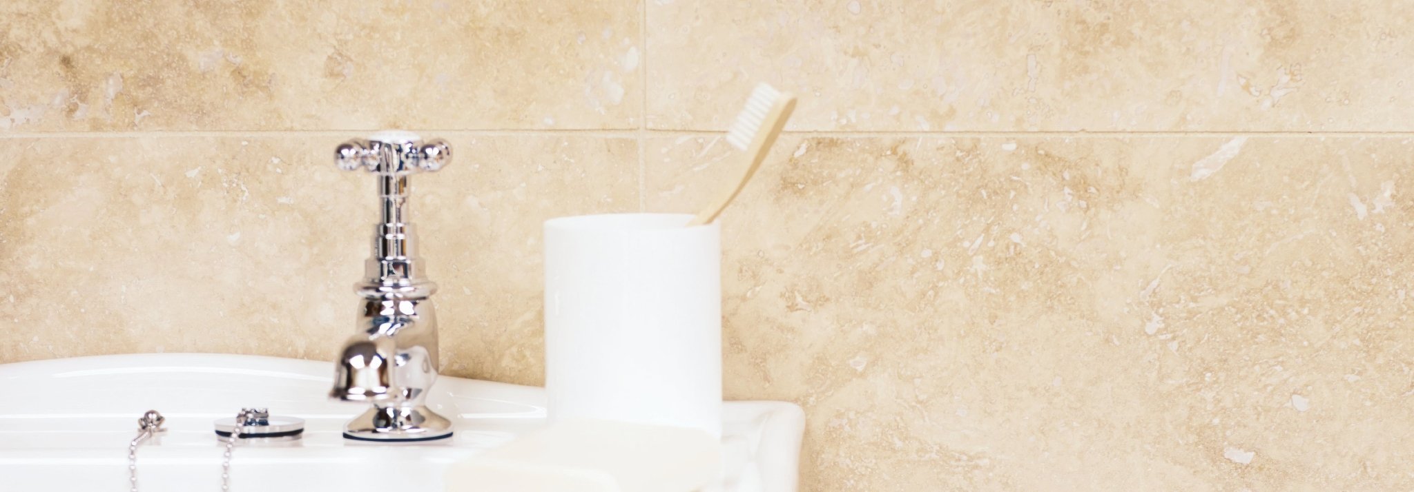 A white ceramic toothbrush holder with a single off-white toothbrush in the Bosphorus collection.