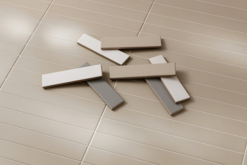 Beige and white rectangular ceramic brick floor tiles scattered on a tiled floor showing smooth surface texture