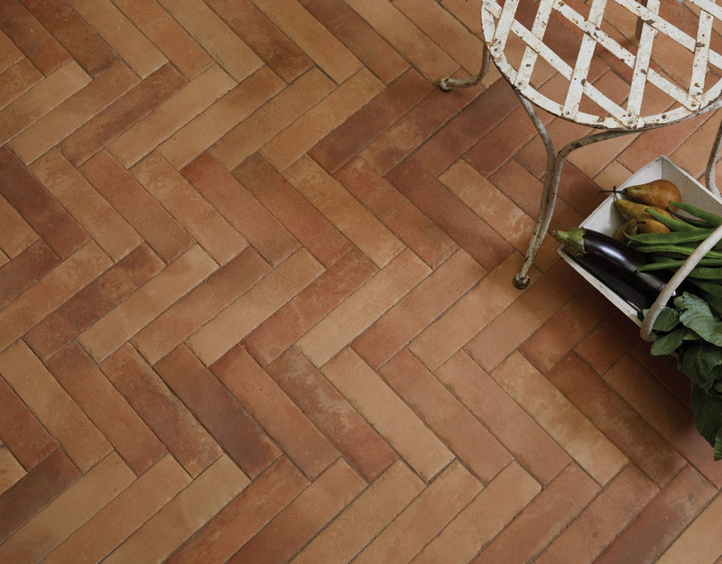 Terracotta rectangular porcelain floor tiles arranged in herringbone pattern from ca pietra interior collection
