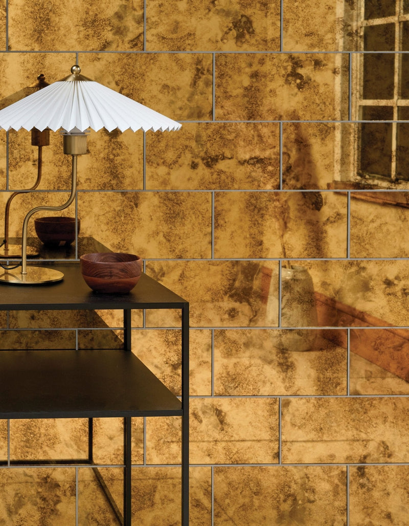 White pleated paper lampshade with metallic base and curved stem in ca’pietra glazed ceramic and mirror tile collection