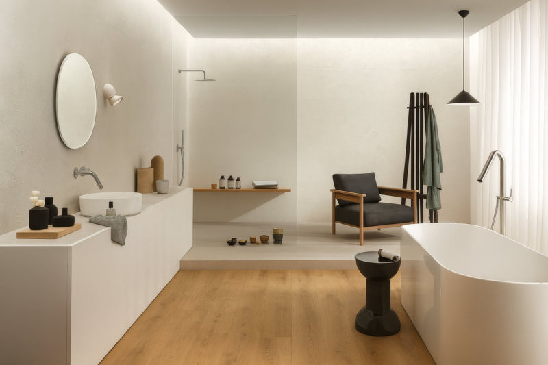 White freestanding bathtub with sleek minimalist design and smooth curved edges in ceramic bathroom tiles collection