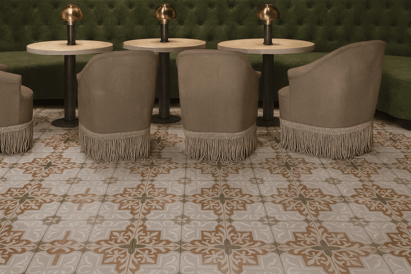 Beige upholstered armchairs with fringe detailing complementing ceramic floor tiles in a stylish living room setting